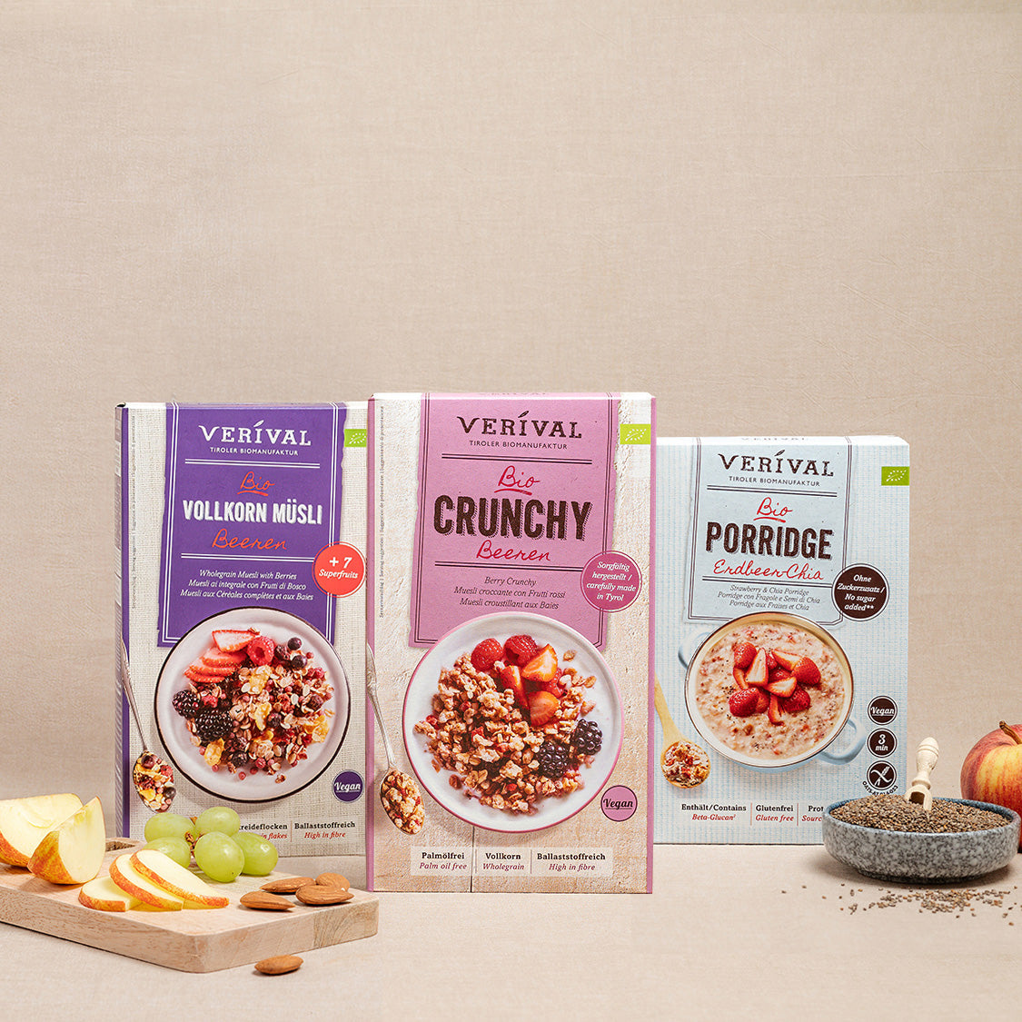 Three boxes of Verival muesli products – Whole Grain Muesli, Crunchy Berries and Porridge – are presented on a neutral background with fruit and muesli props in front.