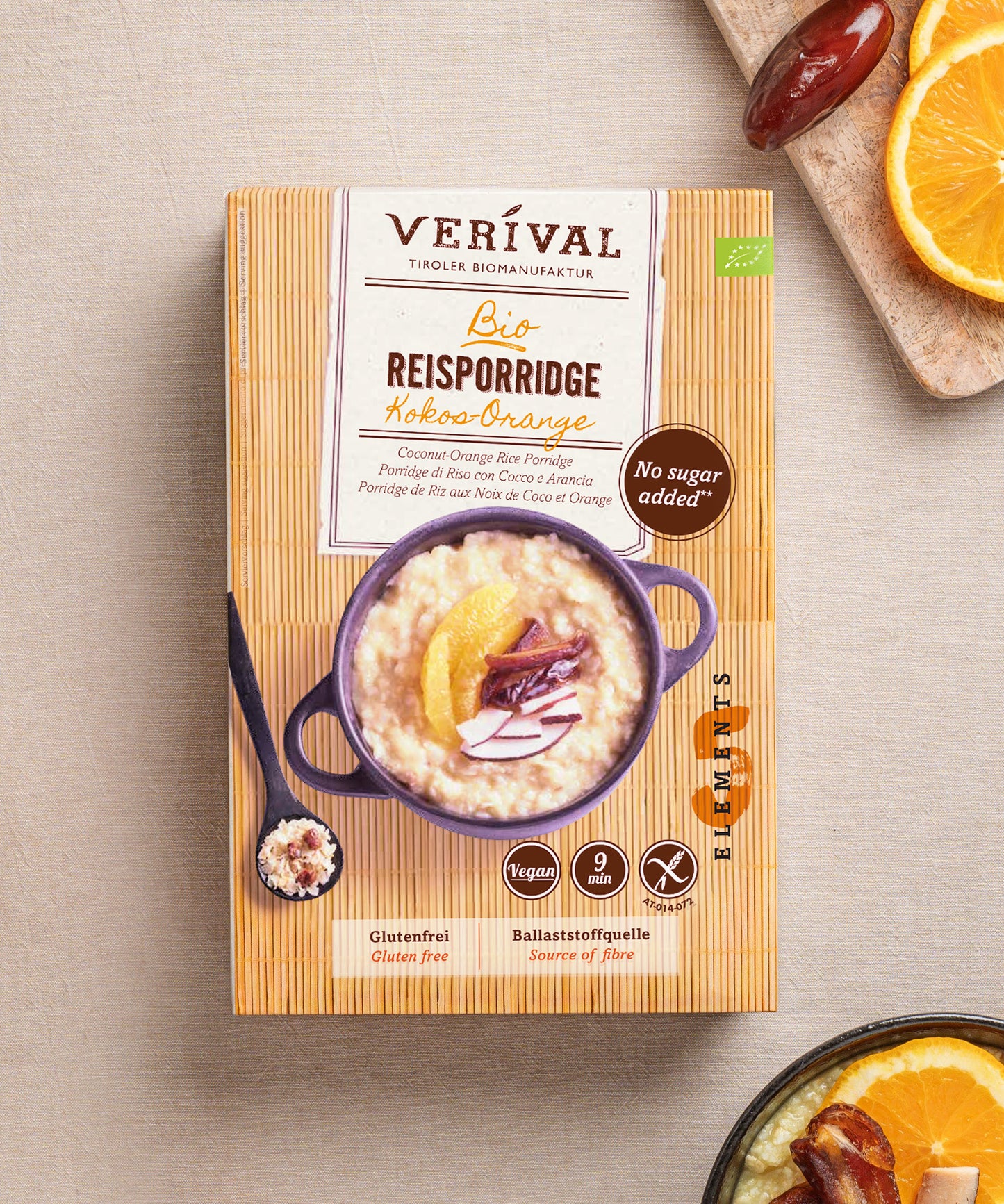 Eine Packung Kokos-Orangen-Reisporridge von Verival Bio steht auf einer strukturierten Oberfläche. Das Rezept dieses glutenfreien Leckerbissens ist von den Prinzipien der TCM-Ernährungslehre inspiriert.