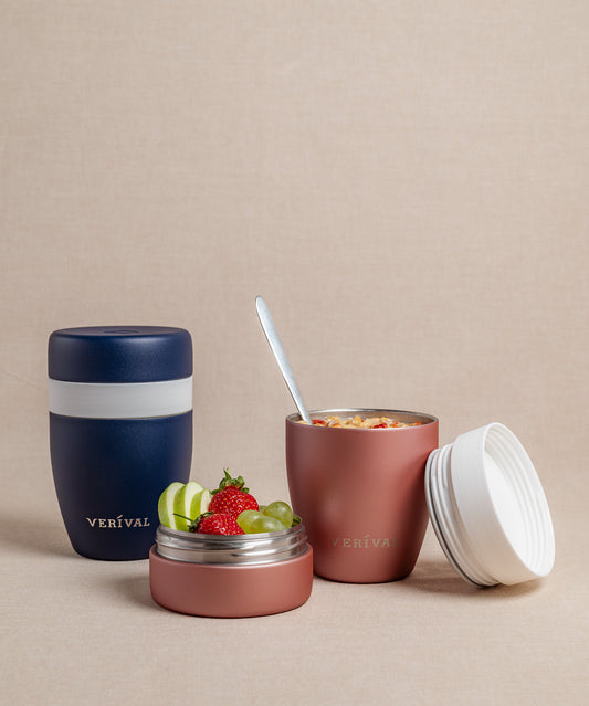 Drei FLSK muki Snackpots gefüllt mit Joghurt, Obst und Snacks stehen auf einer beigen Fläche.