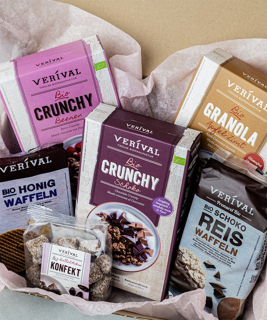 Das Geschenkset „Gute Laune“ von Verival Bio ist wunderschön auf rosa Seidenpapier präsentiert und enthält 100 % Bio Beeren-Granola, Schoko-Granola, Apfel-Zimt Granola, Schoko Reiswaffeln, Honigwaffeln und Dattel-Konfekt – alles von Hand elegant verpackt.