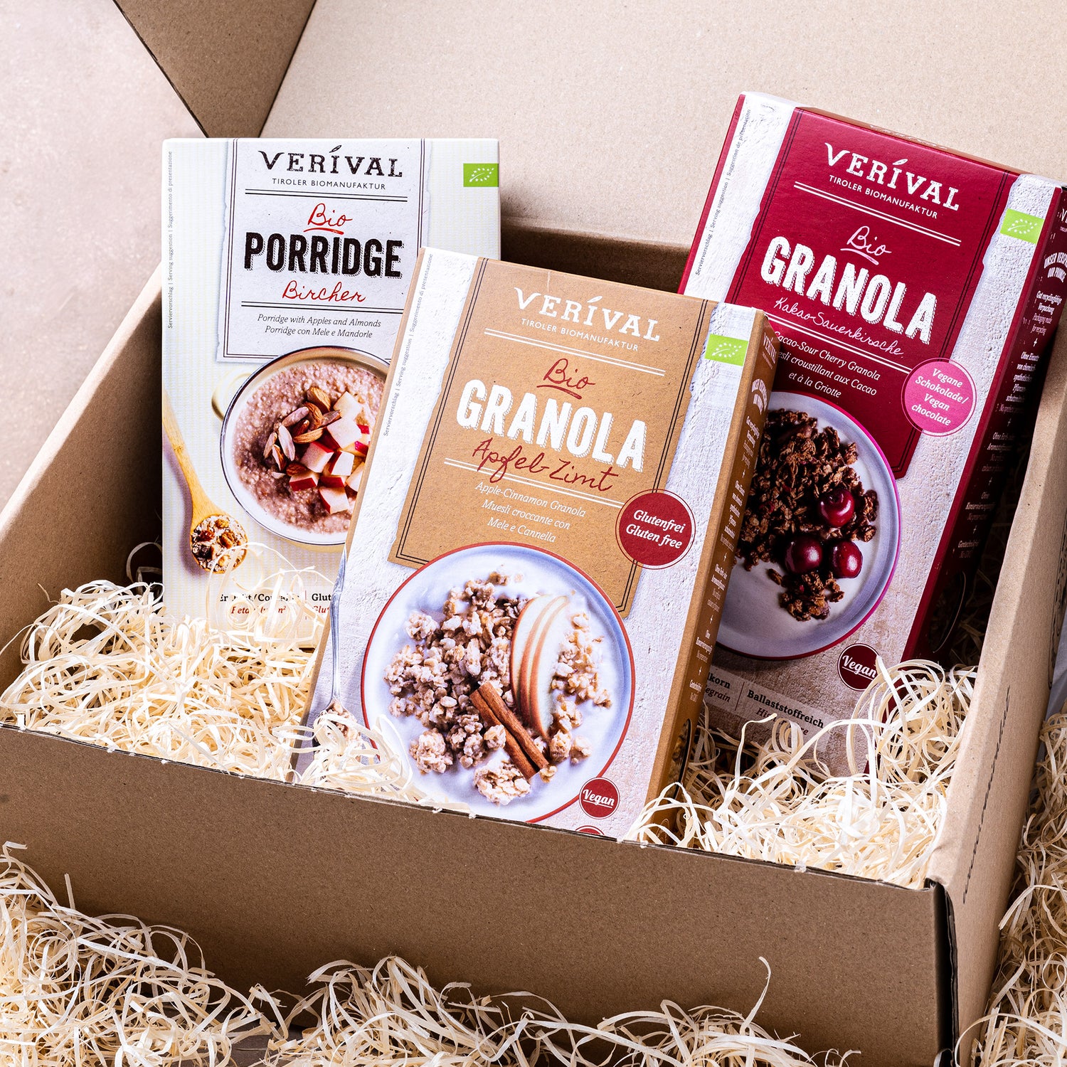Drei Verival Frühstücksprodukte stehen in einer Geschenkbox auf Holzwolle.