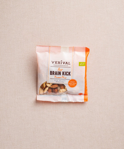 Auf beigem Hintergrund ist eine Packung Brain Kick Nussmischung der Verival Bio GmbH abgebildet, die hochwertige Bio-Nüsse hervorhebt, die als ein perfekter Energiespeicher dienen.