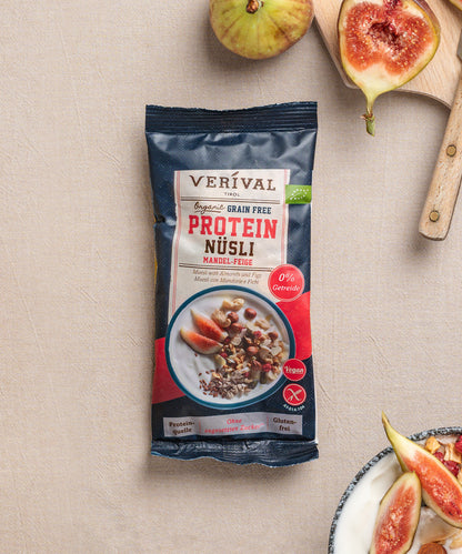 Eine Packung Erdbeer-Chia Porridge der Verival Bio GmbH liegt auf einer beigen Fläche, umgeben von frischen Erdbeeren und einer Schüssel Porridge und ist somit ideal für ein vollwertiges Frühstück.