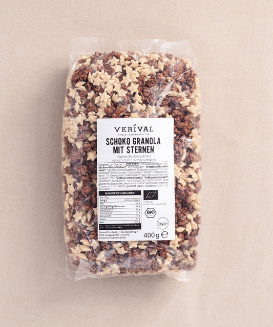 Die Packung "Veganes Schoko Granola mit Sternen" von Verival Bio ist mit Schoko-Granola-Clustern und sternförmigen Müslis gefüllt und ist vegan und palmölfrei. Sie enthält ein Nährwertkennzeichen und ein Bio-Zertifikat.